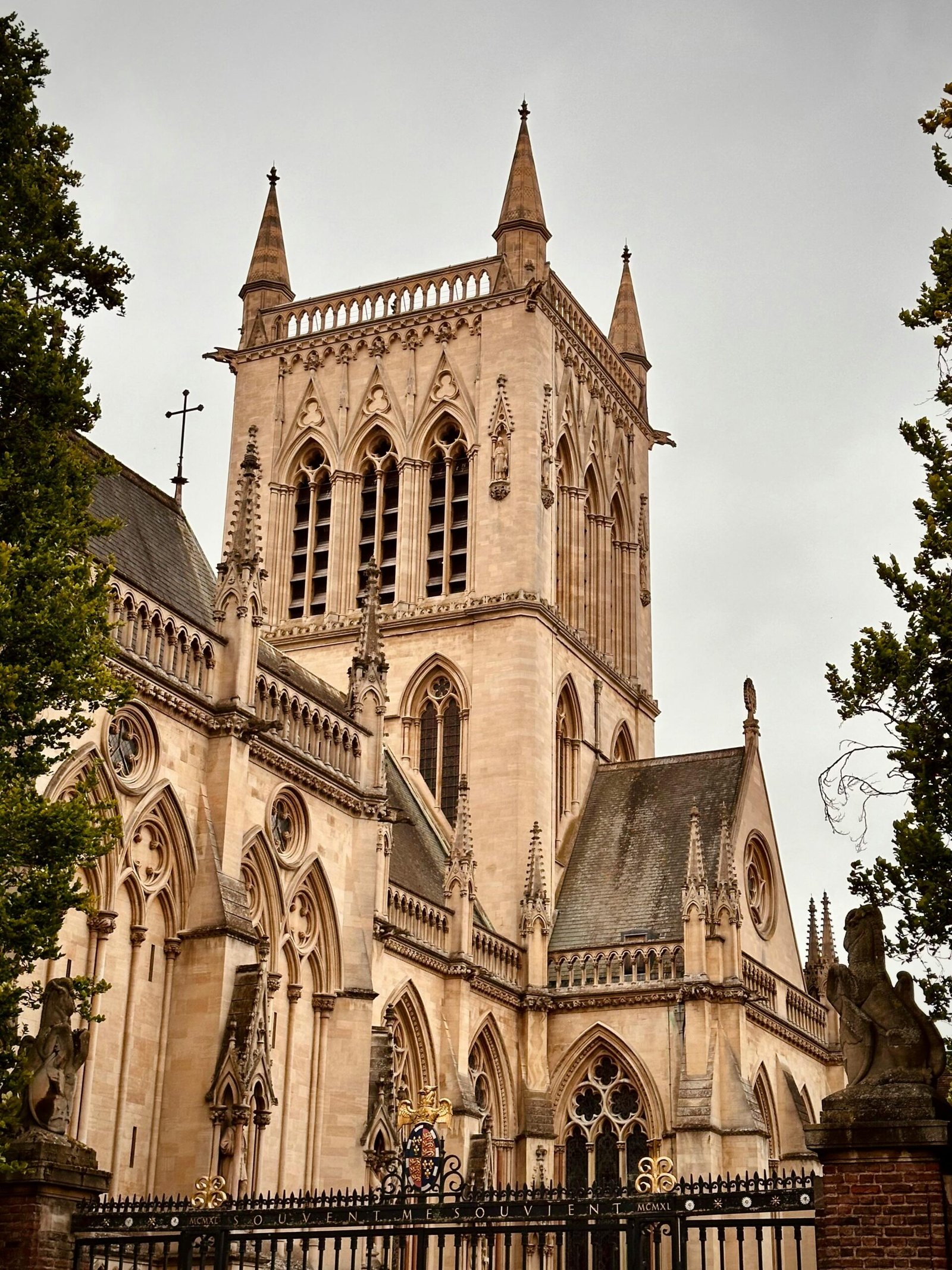 A stunning Gothic Revival church towering in Cambridge, England, amidst overcast skies.